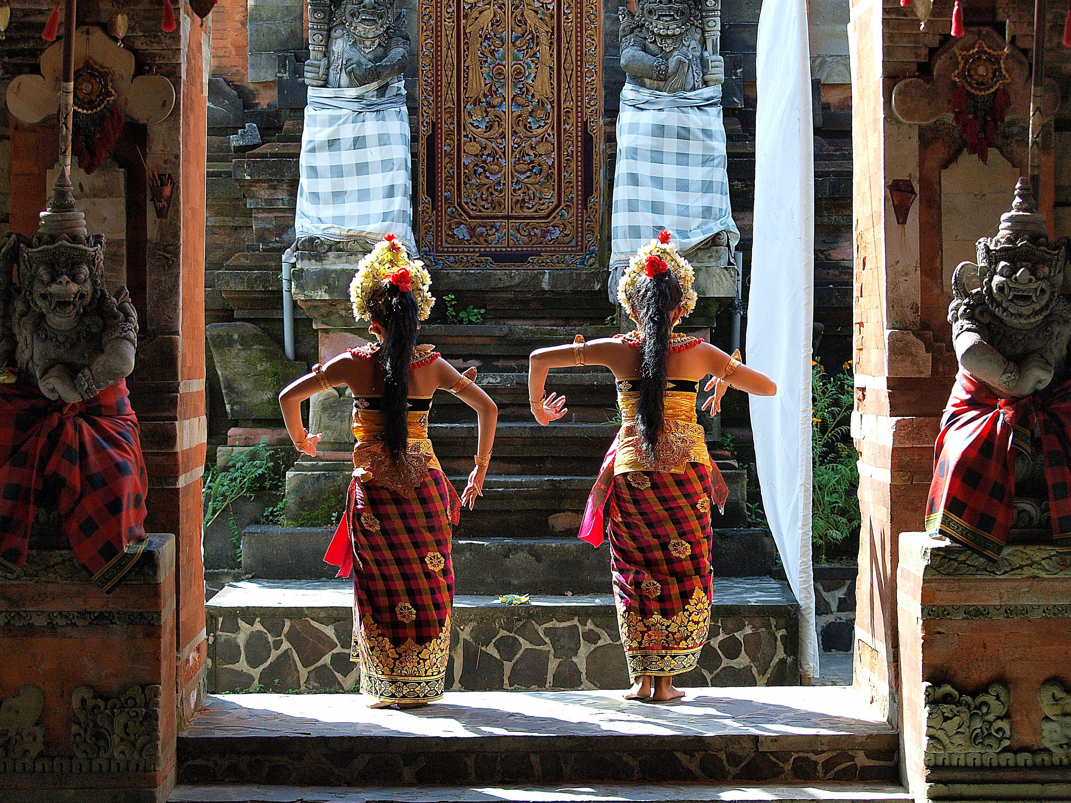 Balinese dancers performing at a temple courtyard
